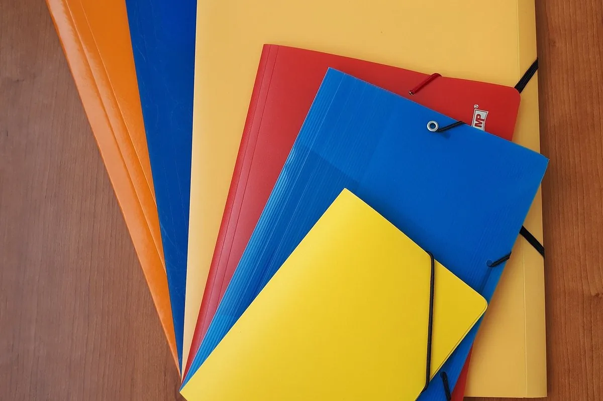 Coloured document folders stacked on a desk