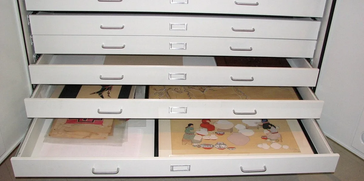Wide flat-file drawers pulled open with papers inside